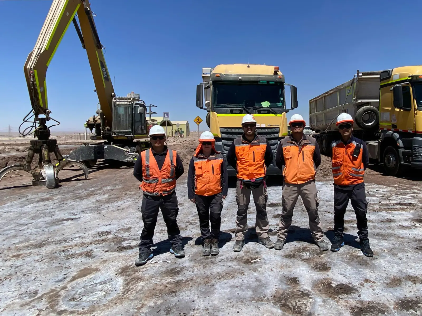 Equipo de Servilinares en terreno frente a camiones y maquinaria