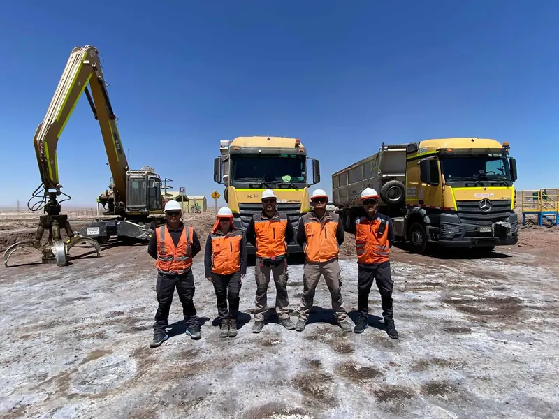 Equipo de Servilinares en terreno junto a camiones y una excavadora