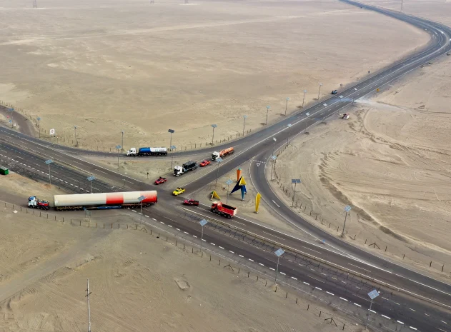 Vista aérea de un convoy con carga sobredimensionada cruzando un enlace de carretera en el desierto